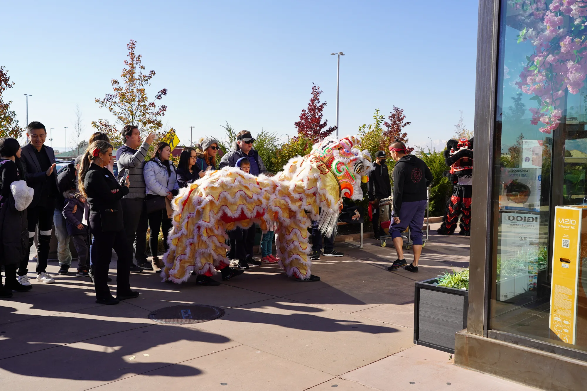 A lion dance and a crowd outside Miyazaki at its grand opening