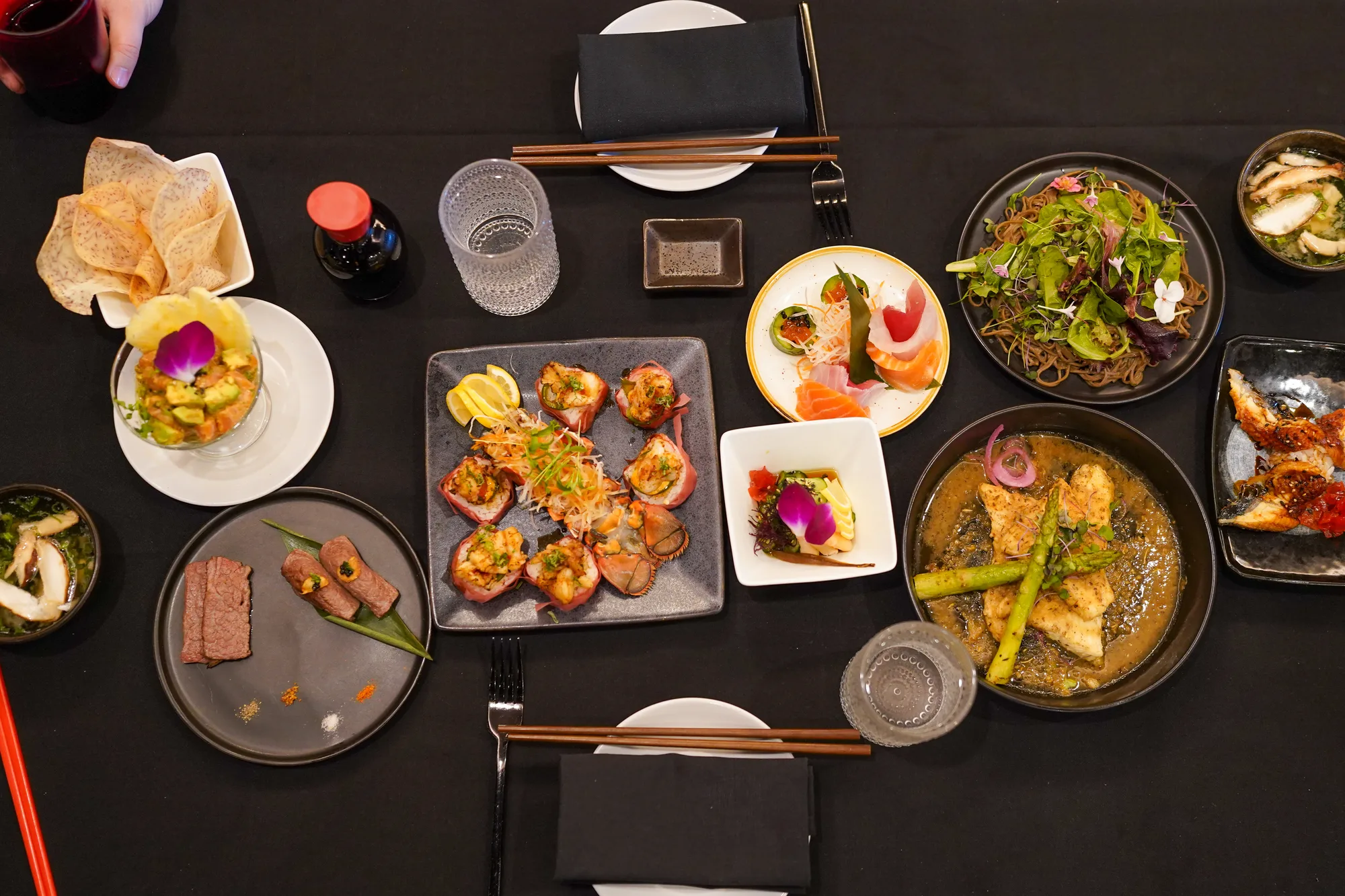 A table set with sushi, small plates and Japanese dishes at Miyazaki
